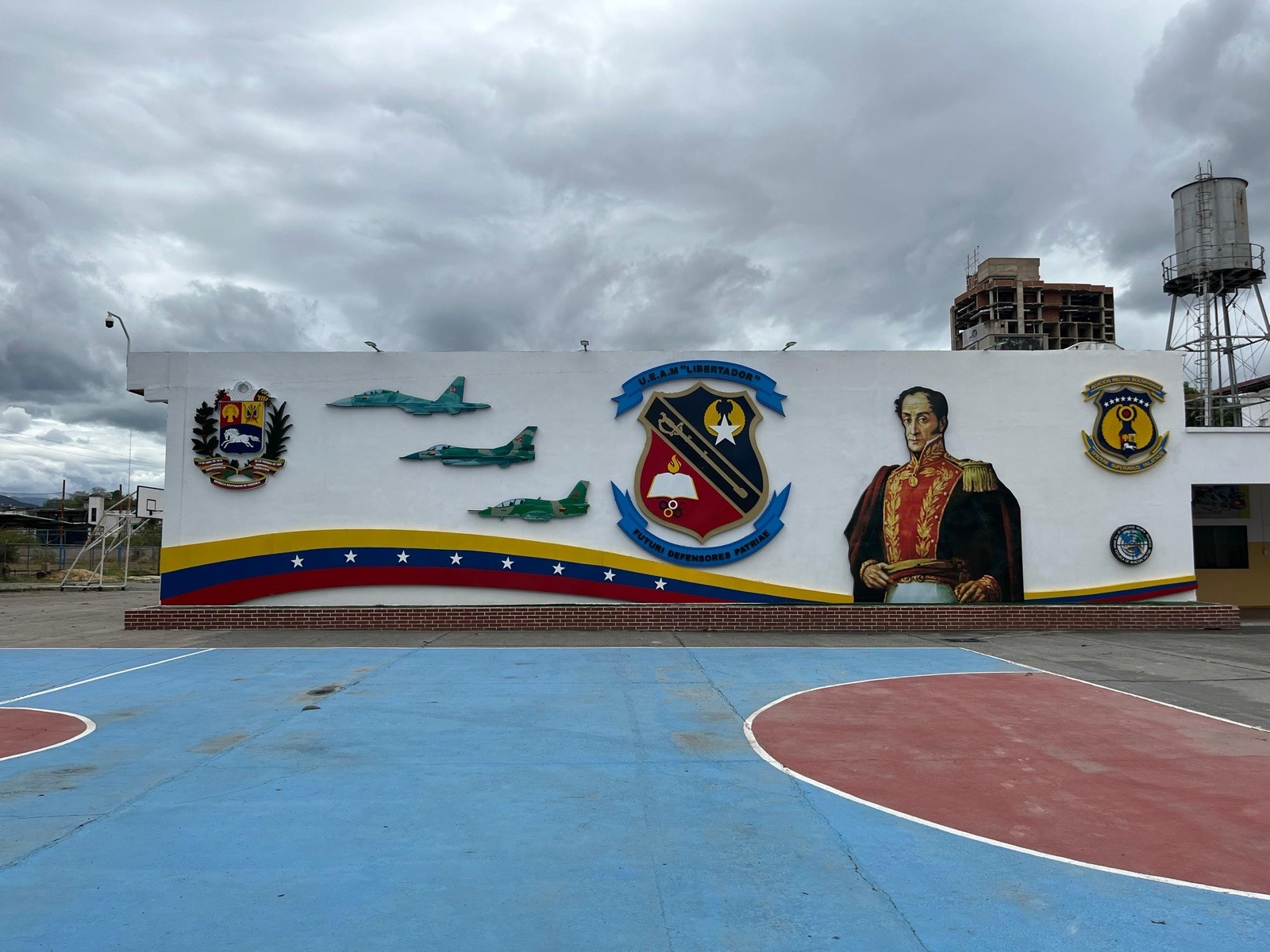 Mural institucional con el Libertador Simón Bolívar, el escudo de la UEAM y aeronaves de la Aviación Militar