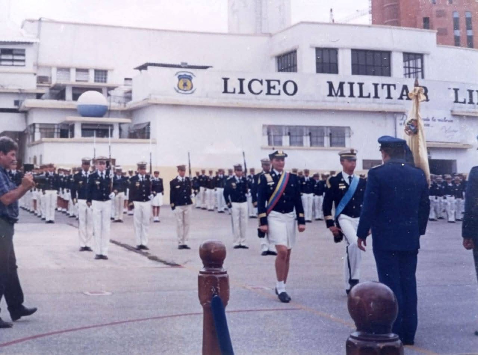 Escolta de bandera histórica posando junto al busto y monumento institucional