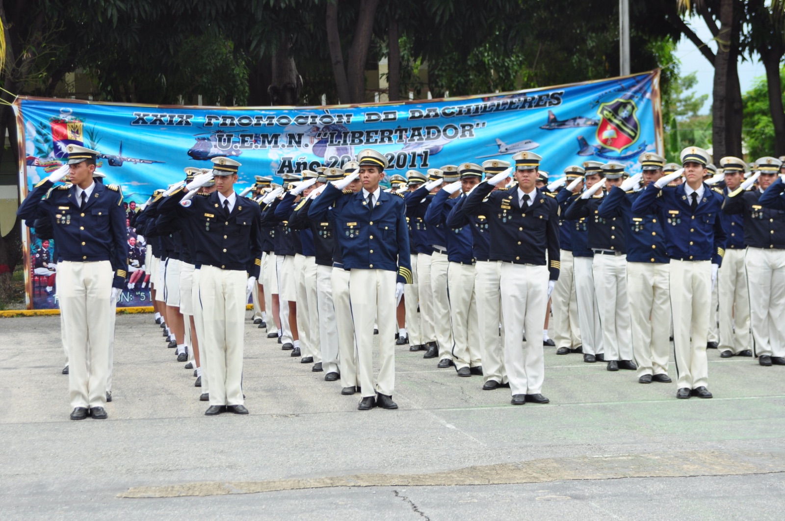 Cadetes de uniforme de gala saludando en formación durante un acto institucional